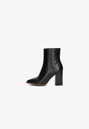 Black leather ankle boot with a pointed toe and a structured block heel. Smooth texture with minimalist design and visible seam details.