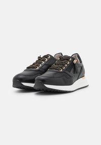 Scarpe da ginnastica nere realizzate in pelle liscia, con lacci neri e dorati, una suola bianca e un dettaglio dorato sul tallone.