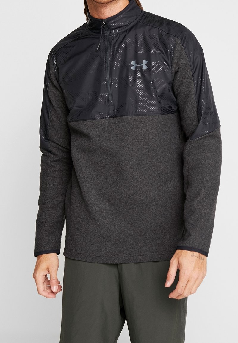 Suéter de hombre en gris oscuro con un cuello de media cremallera. Presenta un panel superior texturizado en negro con detalles de malla y un acento de logo en el pecho.