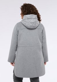 Cappotto grigio in misto lana con cappuccio grigio trapuntato, caratterizzato da una forma dritta, maniche lunghe e design minimalista. Vista posteriore mostrata.