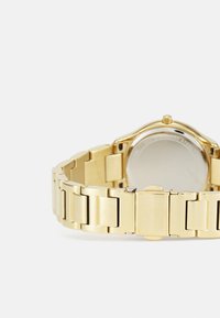 Gold Edelstahl-Uhr mit polierter Oberfläche, runder Zifferblatt, massiven Armbandgliedern und einem sicheren Verschlussmechanismus.
