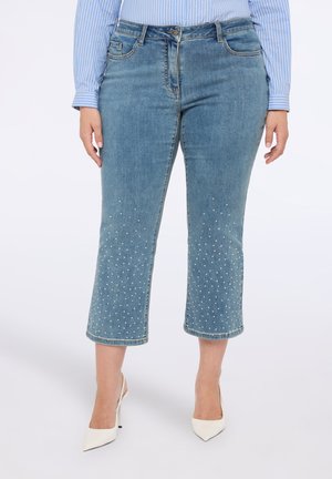 Pantalones capri de mezclilla azul claro con corte recto, adornados con brillantes blancos dispersos en el dobladillo, con un diseño clásico de cinco bolsillos.