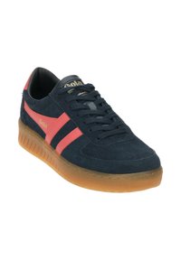 Zapatillas de ante azul marino con rayas rosas, suela de goma texturizada y punta redonda. Logo de Gola visible en el lateral y en la lengua.