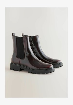Burgundiškos patentinės odos Chelsea botai su elastiniais šoninių panelių, juodu guminio protektoriaus padu ir kilpos, palengvinančios apsiauti.