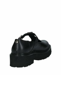 Scarpe con platform in pelle nera, con fasce incrociate, punta arrotondata e suola testurizzata. Presentano un logo metallico sul retro.