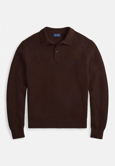 Brun strikket polosweater med krage, med treknappers stolpe og en liten blå logo på brystet. Teksturert stoff.