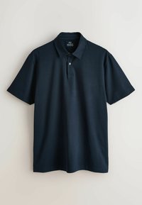 Polo bleu marine à manches courtes avec col et patte à deux boutons, coupe régulière, présenté sur un fond clair uni.