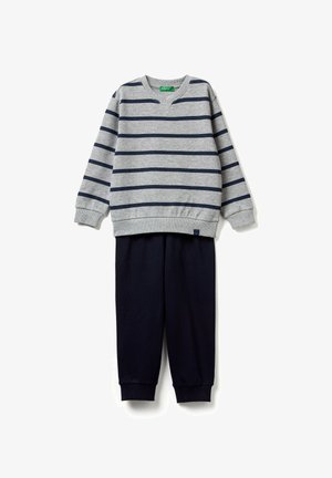 Šedé tričko s dlouhým rukávem s námořnicky modrými horizontálními pruhy v kombinaci s jednobarevnými námořnicky modrými kalhotami, obě se žebrovanými manžetami.