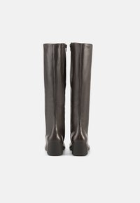 Ψηλές μαύρες δερμάτινες μπότες με λεία υφή, στρογγυλερή μύτη, τακούνι block και κλείσιμο με φερμουάρ ολόκληρου μήκους στο πίσω μέρος.