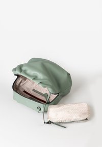 Groene leren tas met een geraffineerde bovenkant, voorzien van een gestreepte stofvoering en een kleine bijpassende ritsportemonnee in beige.