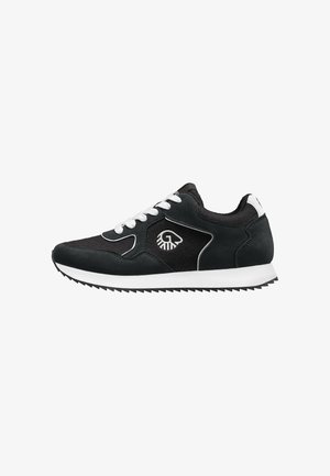 Schwarz-weißer Low-Top-Sneaker mit weißen Schnürsenkeln, strukturierter Sohle und weißem Logo an der Seite vor weißem Hintergrund.