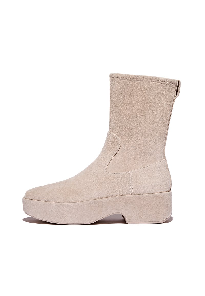 Beige suède enkelboot met een gladde textuur, ronde neus en een dikke, lichtgekleurde plateauzool. Heeft een trekband aan de achterkant.
