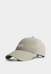 Khaki-Baseballmütze mit gebogenem Schirm, mit gesticktem Text "Babe." Hergestellt aus leichtem Stoff. Verstellbarer Rückenriemen.