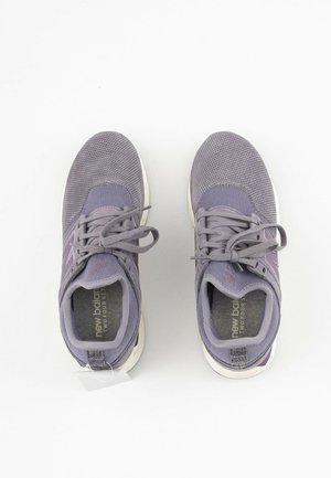 Paire de chaussures de sport grises New Balance avec des lacets, vues de dessus sur un fond blanc.