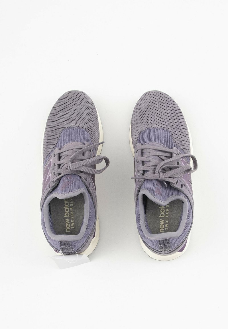 Paire de chaussures de sport grises New Balance avec des lacets, vues de dessus sur un fond blanc.
