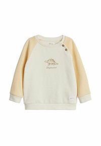 Sweatshirt crème clair avec des manches raglan jaunes, présentant une broderie de dinosaure et des accents de boutons sur l'épaule. Tissu doux, coupe décontractée.