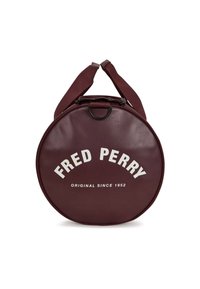 Borsa rotonda bordeaux in materiale sintetico, con chiusura a zip superiore e branding bianco "FRED PERRY" con la scritta "ORIGINAL SINCE 1952".