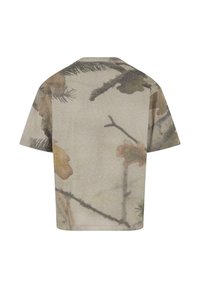 Kortermet T-skjorte med rund hals i dempet beige, med et kamuflasjemønster av blader og grener i jordfarger. Glatt tekstur.