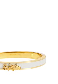 Gold-tone bangle bracelet featuring a white enamel band and a detailed horse-and-carriage charm. Smooth finish with polished accents.