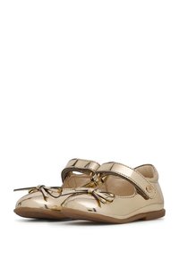 Zlaté lakované Mary Jane boty s kulatou špičkou, detailem mašle vpředu a páskem přes nárt pro bezpečné upevnění.