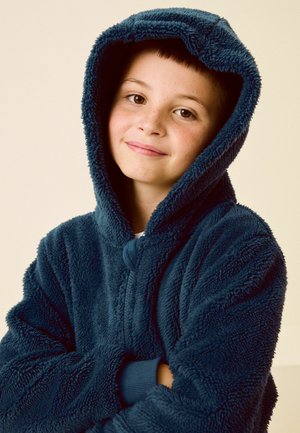 Hoodie en polaire bleu marine avec un extérieur en peluche texturée, grande capuche et fermeture à boutons sur le devant. Comprend des poignets côtelés et une coupe décontractée.