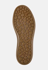 Suola di scarpa in gomma marrone con texture circolari e marchio "CAMPER". Presenta bolle di diverse dimensioni per migliorare la presa e un indicatore di misura "38".