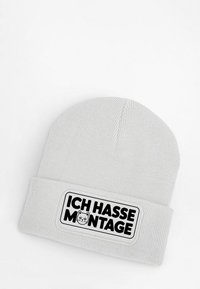 Gray knit beanie with a folded cuff, featuring a rectangular patch that displays the text "ICH HASSE MONTAGE" and a cat graphic.