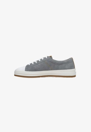 Szare zamszowe sneakersy z białym gumowym czubkiem i podeszwą, z białymi sznurówkami oraz brązowym akcentem na pięcie. Gładka tekstura i casualowy styl.