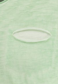 Lichtgroen shirt met korte mouwen, gekenmerkt door een textuurstof, een zak met een ovale uitsnijding en een ronde halslijn.