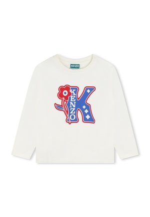 Crème T-shirt met lange mouwen, voorzien van een blauw en rood grafisch ontwerp met de letter "K", bloemen en diamantvormen. Zachte katoen.