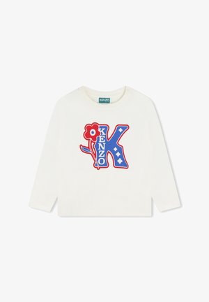 Crème T-shirt met lange mouwen, voorzien van een blauw en rood grafisch ontwerp met de letter "K", bloemen en diamantvormen. Zachte katoen.