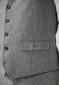 Grau gestreifter Weste aus strukturiertem Stoff mit sechs schwarzen Knöpfen und einer Tasche auf der linken Seite.