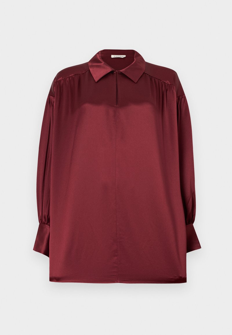 Long-sleeve burgundy satin blouse with a pointed collar, pleated shoulders, and buttoned cuffs against a plain background.