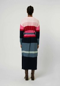 Lång, stickad, flerfärgad klänning med horisontella ränder i nyanser av rosa, blå och marinblå. Inkluderar midjeband och sidoflikar.