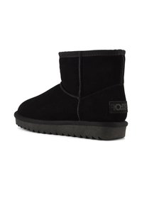 Stivaletti neri in suede, con punta arrotondata, dettagli cuciti e una suola in gomma testurizzata con motivo a zigzag. Accentuati da una patch con logo.