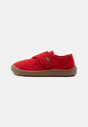 Roter Filz-Slipper mit verstellbarem Klettverschluss und brauner Gummisohle, seitlich auf weißem Hintergrund gezeigt.
