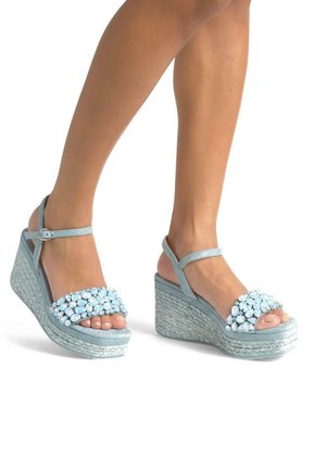 Sandali wedge azzurri chiari con una piattaforma intrecciata testurizzata, una larga cinghia decorata con gemme trasparenti e cinturini alla caviglia regolabili.