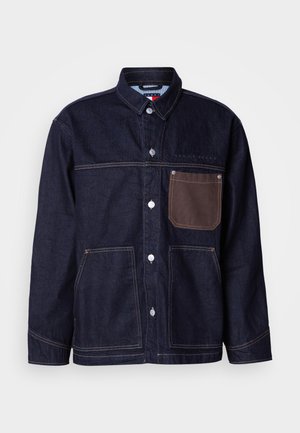 Τζιν μπουφάν σε σκούρο μπλε με γιακά, κλείσιμο μπροστά με κουμπιά και δύο μεγάλες τσέπες. Διαθέτει καφέ διακοσμητική λεπτομέρεια στην τσέπη και αντίθετη ραφή.