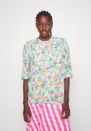 Blusa leve de várias cores com um padrão floral, mangas curtas em forma de puff e decote redondo, feita de um tecido suave.