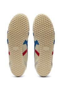 Sneakers med en texturerad gummisula, med en krämfärgad kropp, blå och röda accenter, samt ett distinkt triangulärt mönster på yttersulan.