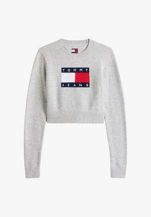 Suéter gris corto con puños y dobladillo acanalados, con un logo rectangular azul marino y rojo que dice "TOMMY JEANS" centrado en el frente.