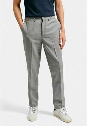 Ljusgrå byxor med en texturerad tyg, tapered fit, rak front och sidofickor, som kombineras med vita sneakers och en marinblå skjorta.