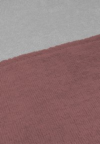 Rechteckiger Baumwollteppich mit strukturierter Oberfläche, der einen maronisierten Abschnitt und einen grauen Abschnitt aufweist, beide mit einem weichen, geschlungenen Gewebemuster.