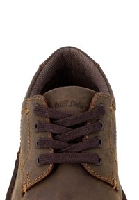 Braune Lederschuhe mit braunen Schnürsenkeln, ausgestattet mit einem strukturierten Inneren und Kontrastnähten. Die Marke 'Gusti Leder' ist auf der Zunge geprägt.