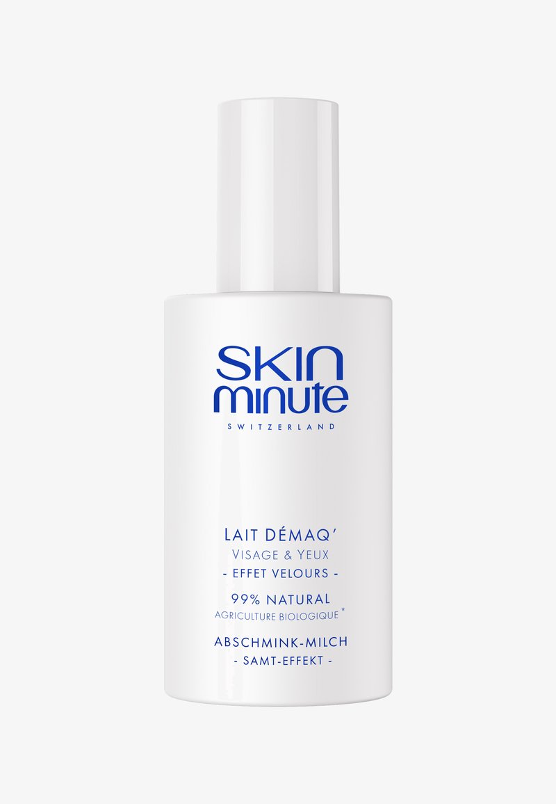 Bottiglia cilindrica bianca con un tappo a pompa, etichettata "SKIN minute" in bold blu. Contiene "Lait Démaq'" per viso e occhi, 99% naturale.