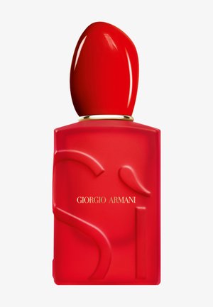 Flacon de parfum en verre dépoli rouge avec un design embossé incurvé, grand bouchon rouge brillant, et "Giorgio Armani" écrit en lettres dorées.