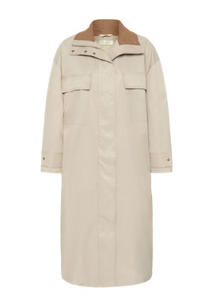 Dlouhý béžový kabát se zapínáním na zatrhávací knoflíky a zip, klopové kapsy na hrudi a kontrastní hnědý manšestrý límec.