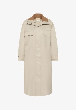 Dlouhý béžový kabát se zapínáním na zatrhávací knoflíky a zip, klopové kapsy na hrudi a kontrastní hnědý manšestrý límec.