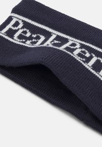 Námornícky pletený čelenka s bielym logom "Peak Performance" na prednej strane. Textúra je mäkká a ryhovaná, s prehnutým dizajnom.