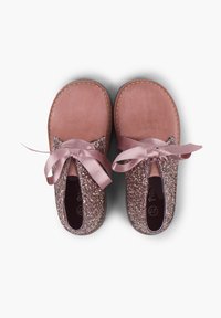 Scarpe in suede rosa con una tomaia glitterata e scintillante e morbidi lacci in raso. Il design include un'apertura elastica per facilitare l'indossamento.
